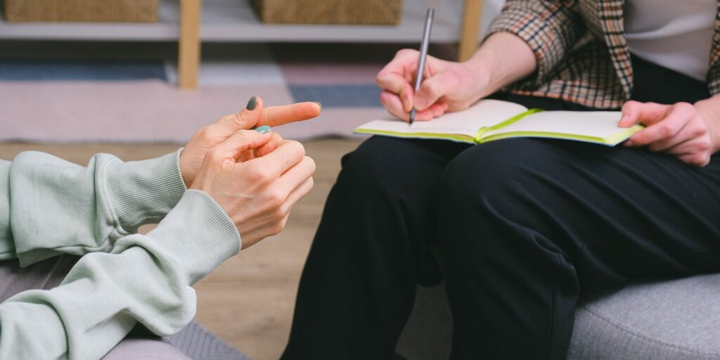 Two small business owners talk, with one taking notes.