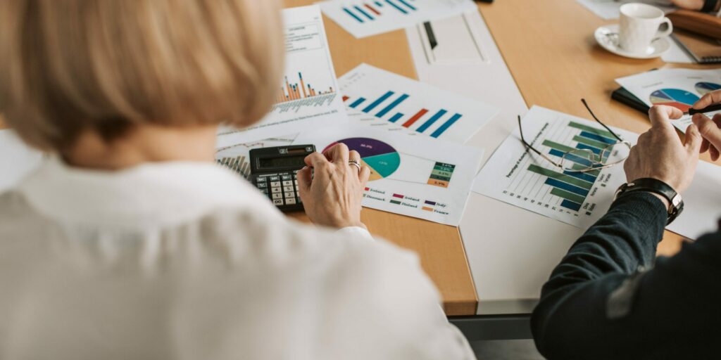 Two lender employees look over a small business's financials.