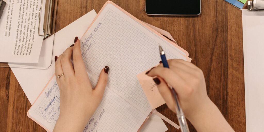 A small business owner writes in a notebook.