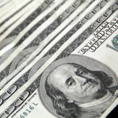 Several $100 bills laid out together