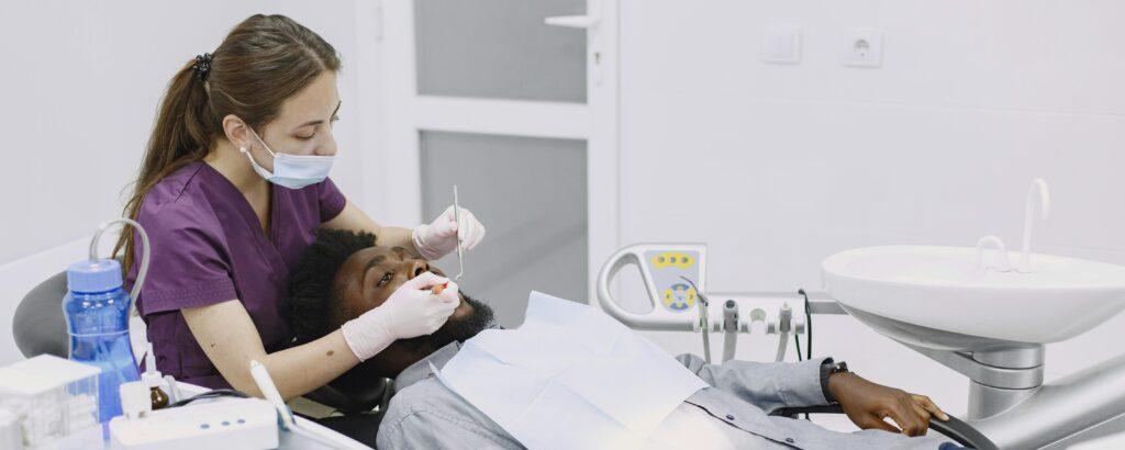 A dental hygienist giving a tooth cleaning.