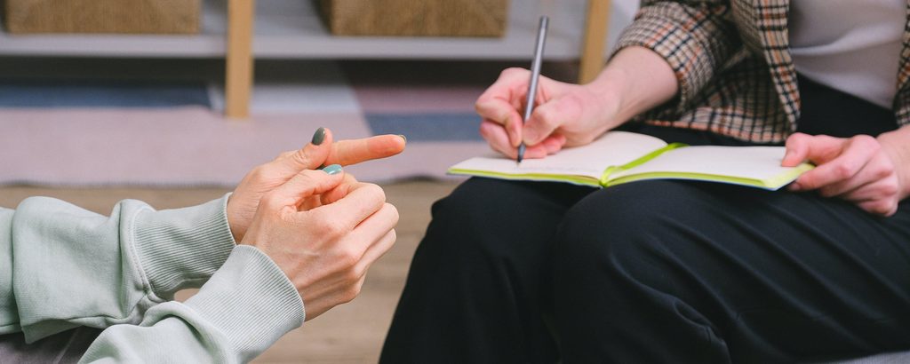 Two small business owners talk, with one taking notes.